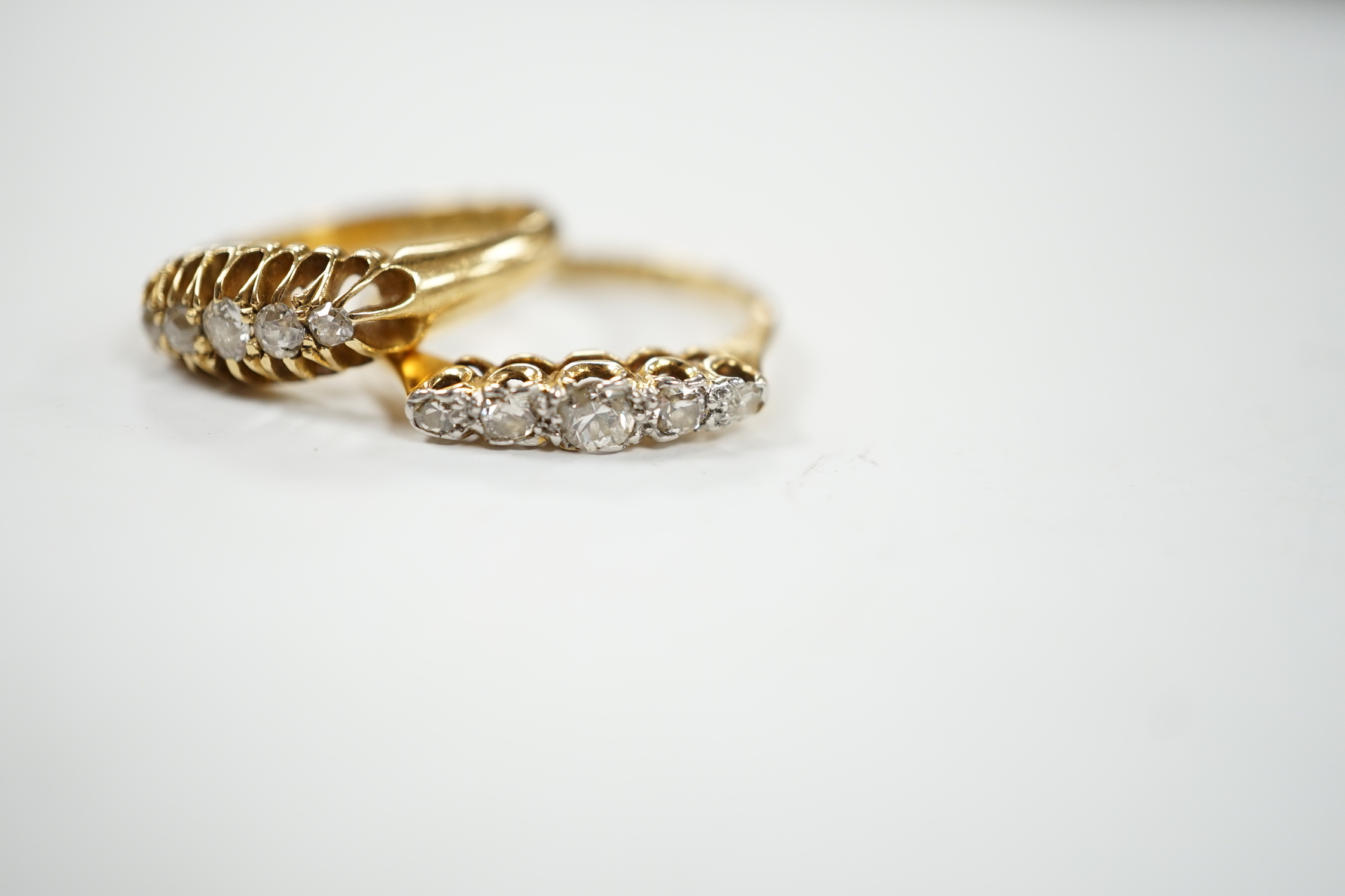 Two early 20th century 18ct gold and graduated five stone diamond set half hoop rings